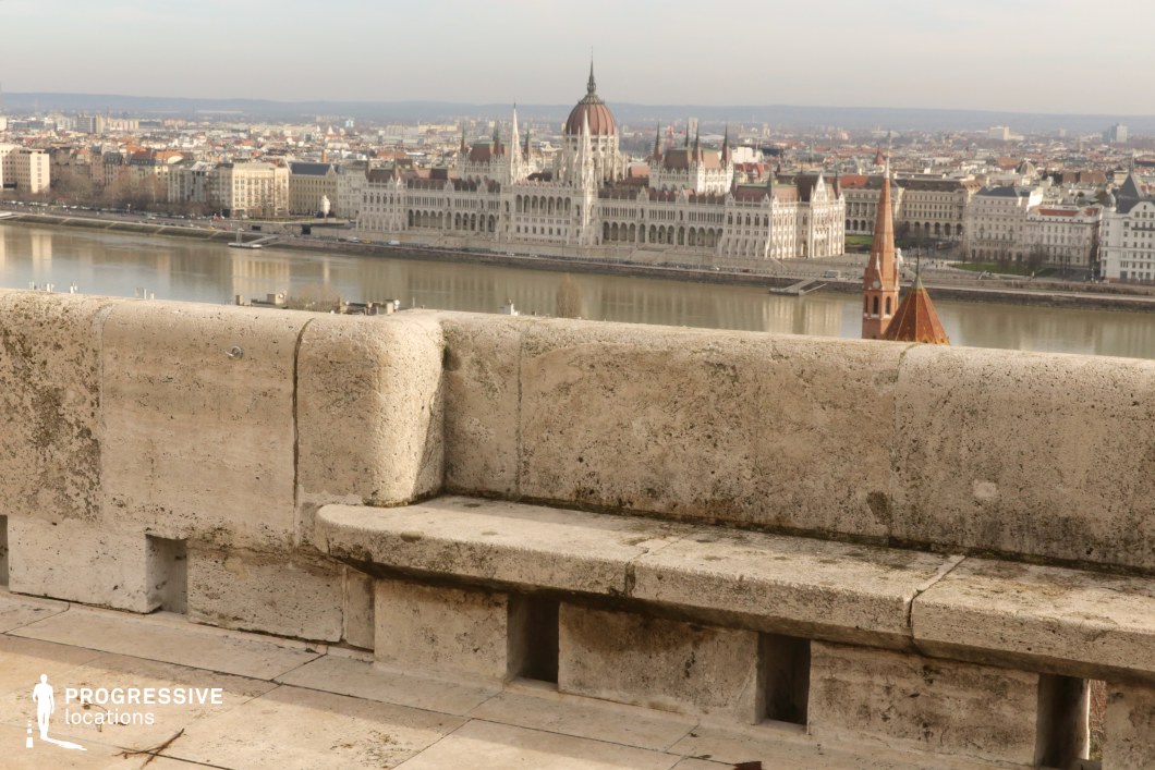 Stone terrace edge overlooking river and city, a photography and film location with open view and strong foreground lines