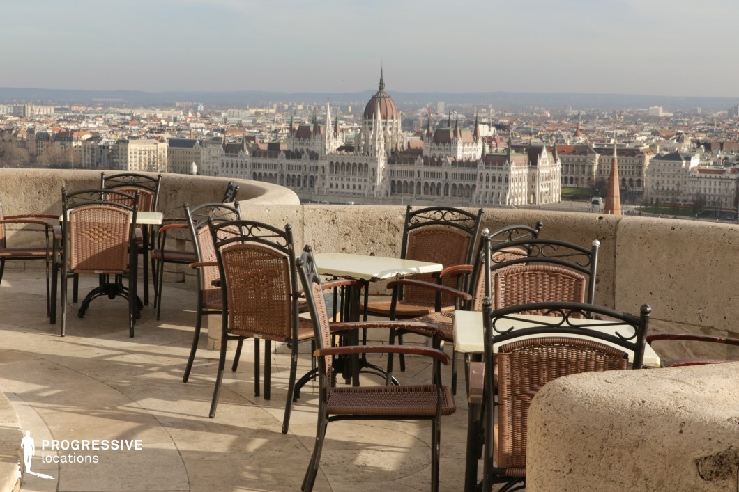 Terrace with café seating overlooking cityscape, an ideal location for photography and filming with open urban backdrop