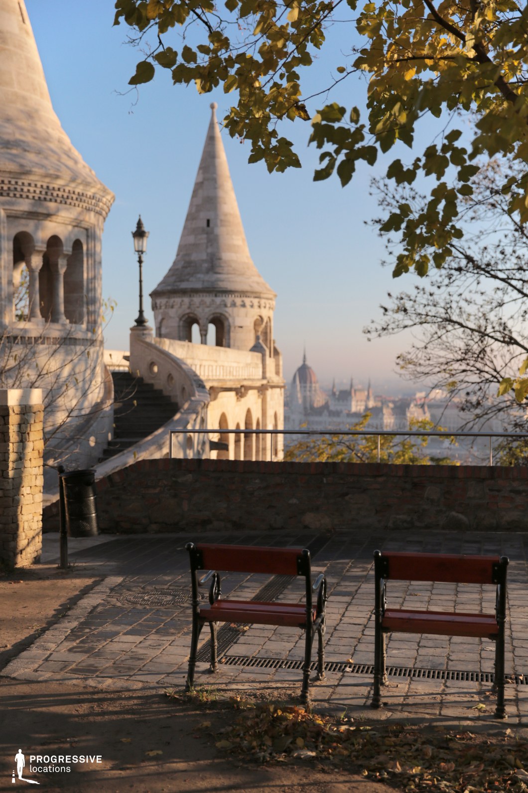 Benches near stone towers on terrace, photography and film location with layered architecture and distant city view