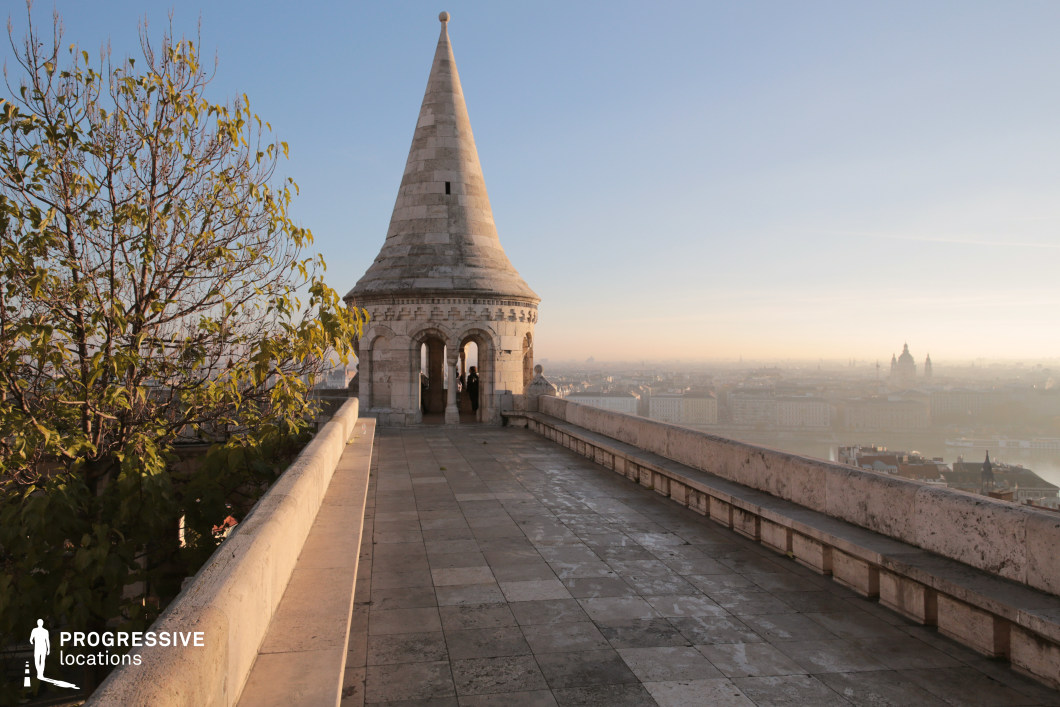 Stone terrace leading to tower, a film and photography location with linear perspective and elevated urban backdrop