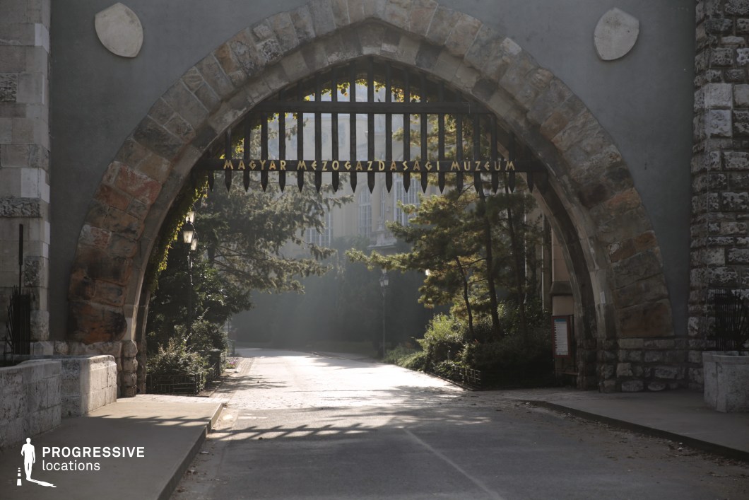Large stone arch gateway over a road, photography and film location with strong framing and textured masonry