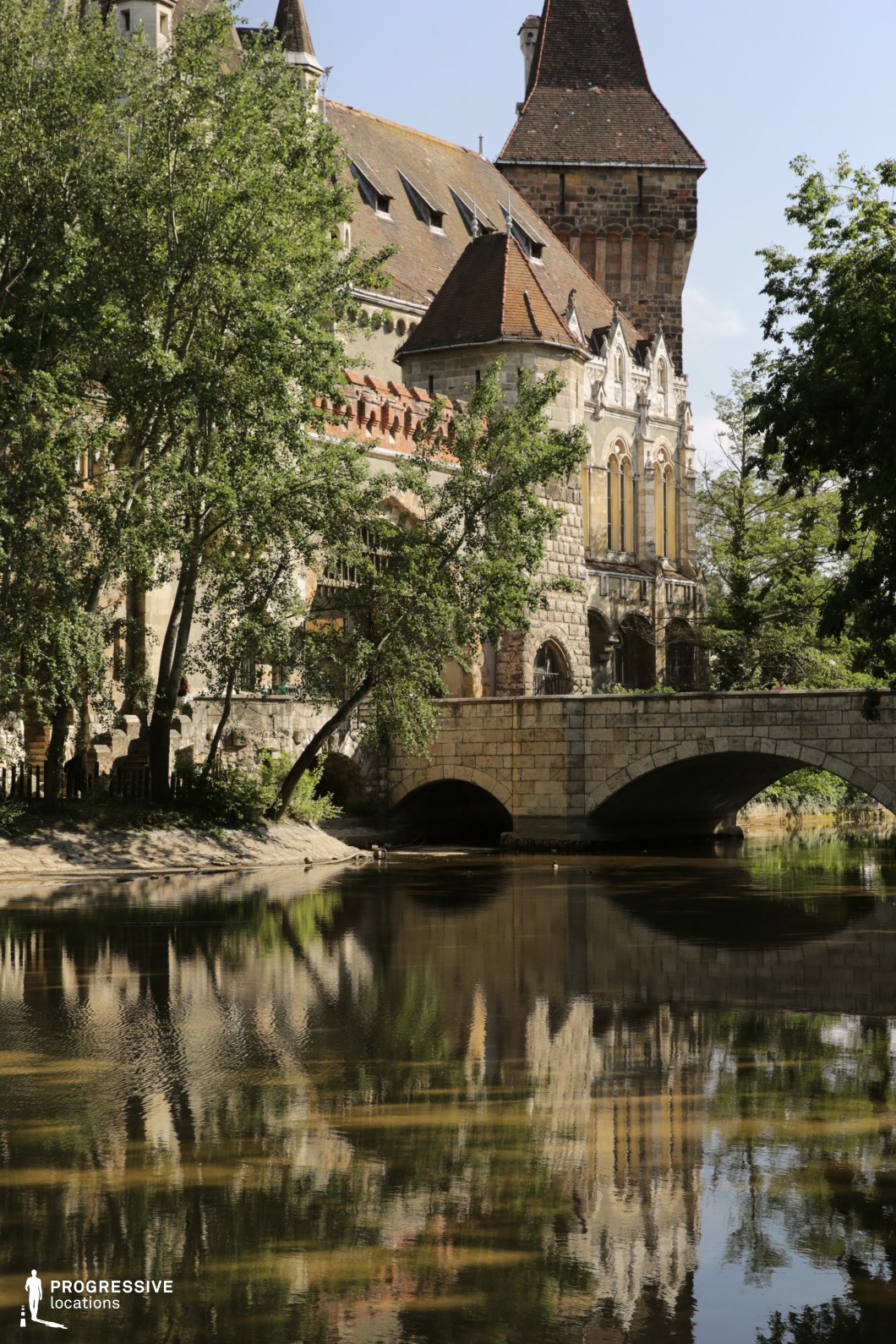 Historic castle and stone bridge reflected in water, film and photography location with symmetry and detailed architecture