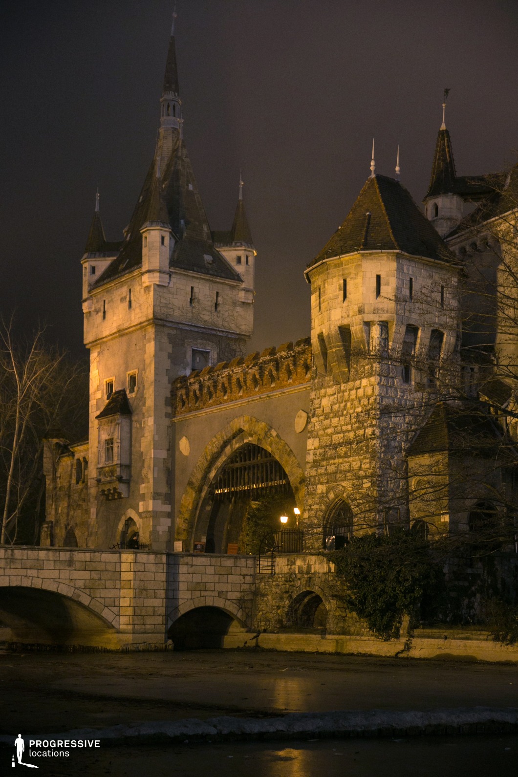 Fortified castle gate with towers and bridge, photography and film location with strong vertical structure and stone details