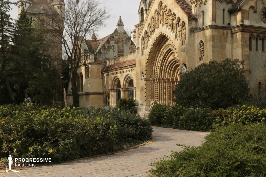 Detailed historic building with arched facade and pathway, available for filming or photo shoots with rich stone textures