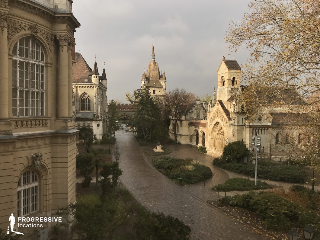 Large historic courtyard with towers and ornate buildings, ideal location for photography and filming with central paved space