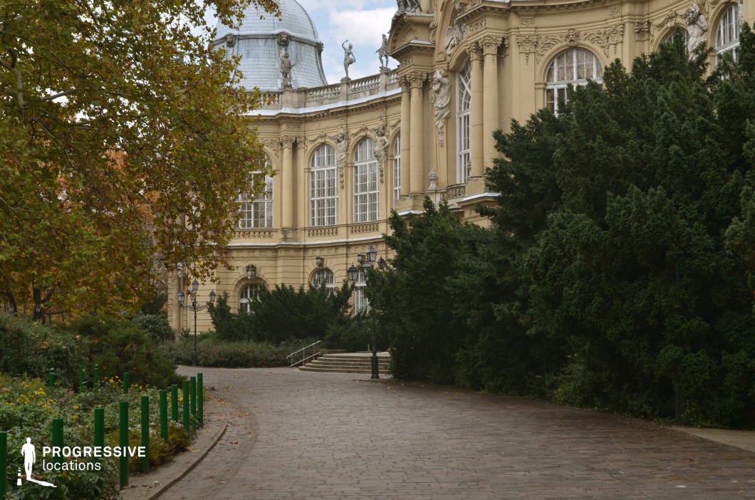 Ornate palace facade with curved garden path, film and photography location featuring classical columns and greenery