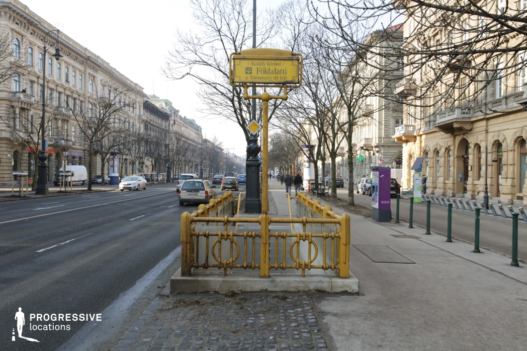 Metro entrance railings on boulevard create a film and photography location with strong central perspective and urban depth