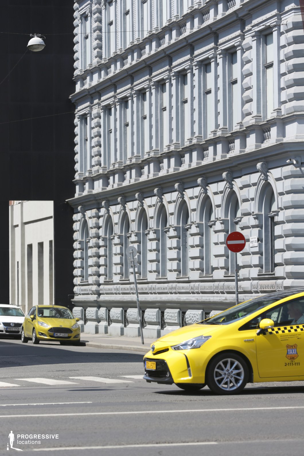 Neoclassical street facade with arched windows creates a film and photography location with strong architectural rhythm