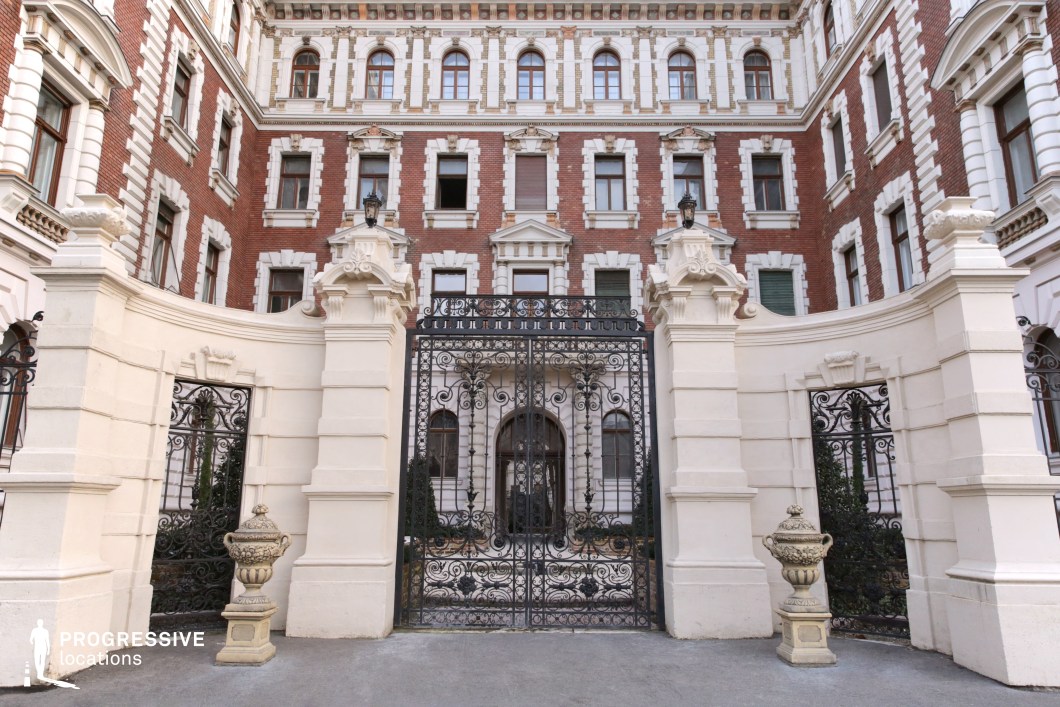 Ornate wrought iron gate and courtyard entrance form a photography and film location with symmetrical composition