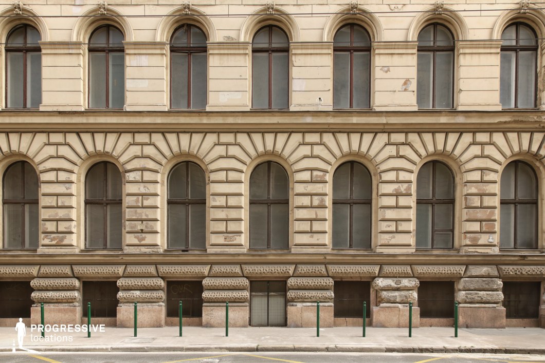 Repetitive arched windows on textured facade create a film and photography location with strong geometric pattern