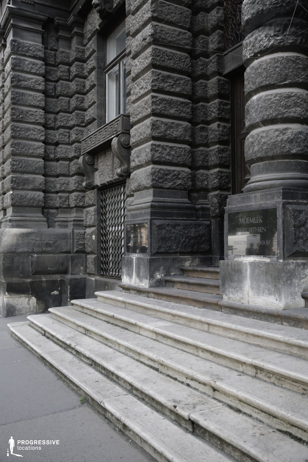 Stone steps leading to heavy masonry entrance create a shooting location for film and photography projects with strong depth
