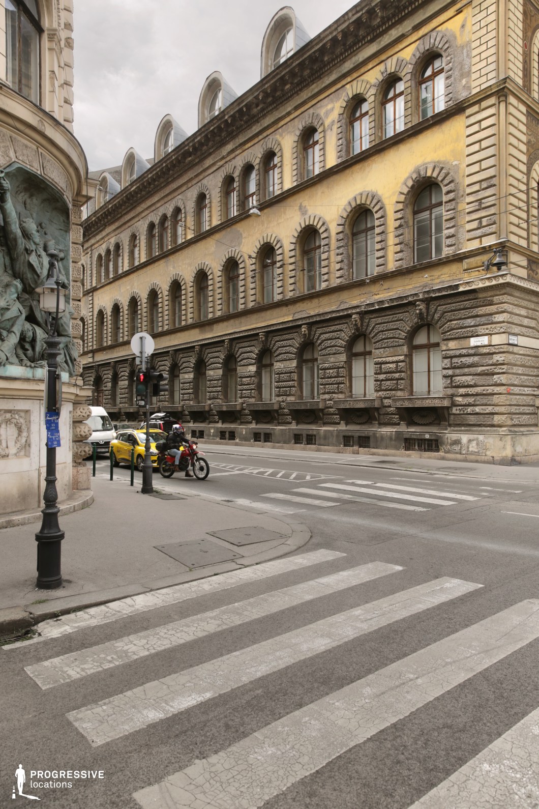 Aged yellow facade with repetitive arched windows forms a photography and film location with strong linear rhythm
