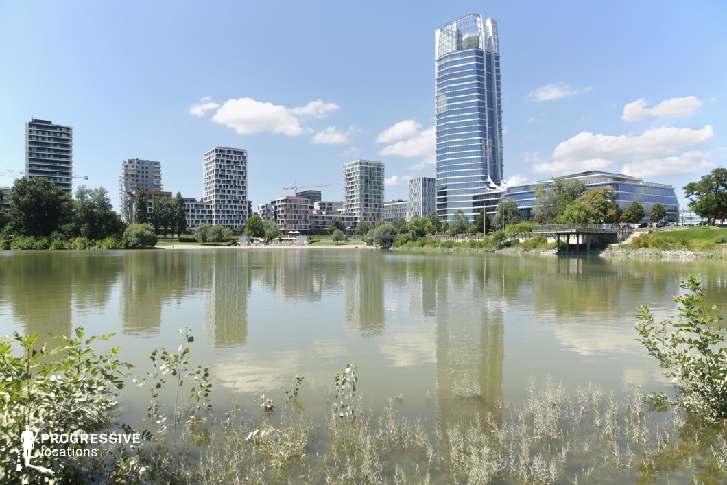 Lake with skyline reflection, photography and film location with modern buildings and water foreground