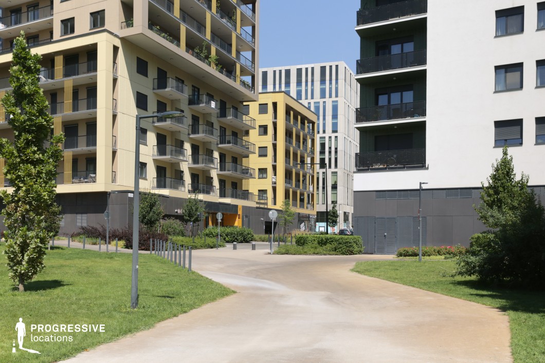 Residential path with greenery and modern apartments, photography and film location with open layout