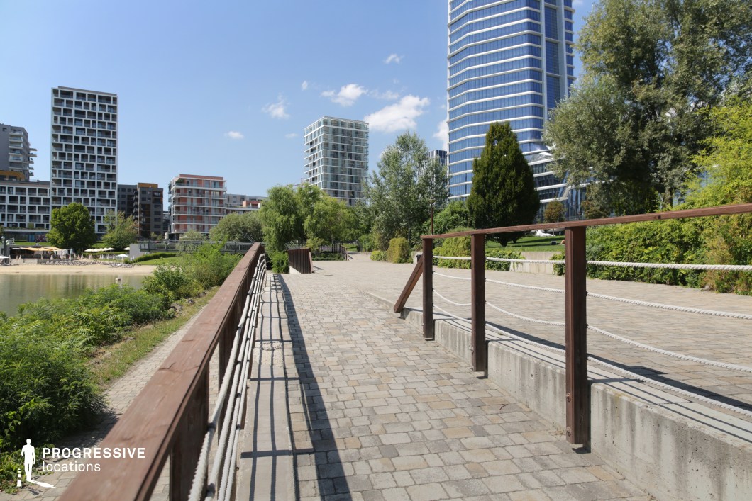 Riverside walkway with bridge and modern skyline, ideal location for photography and filming