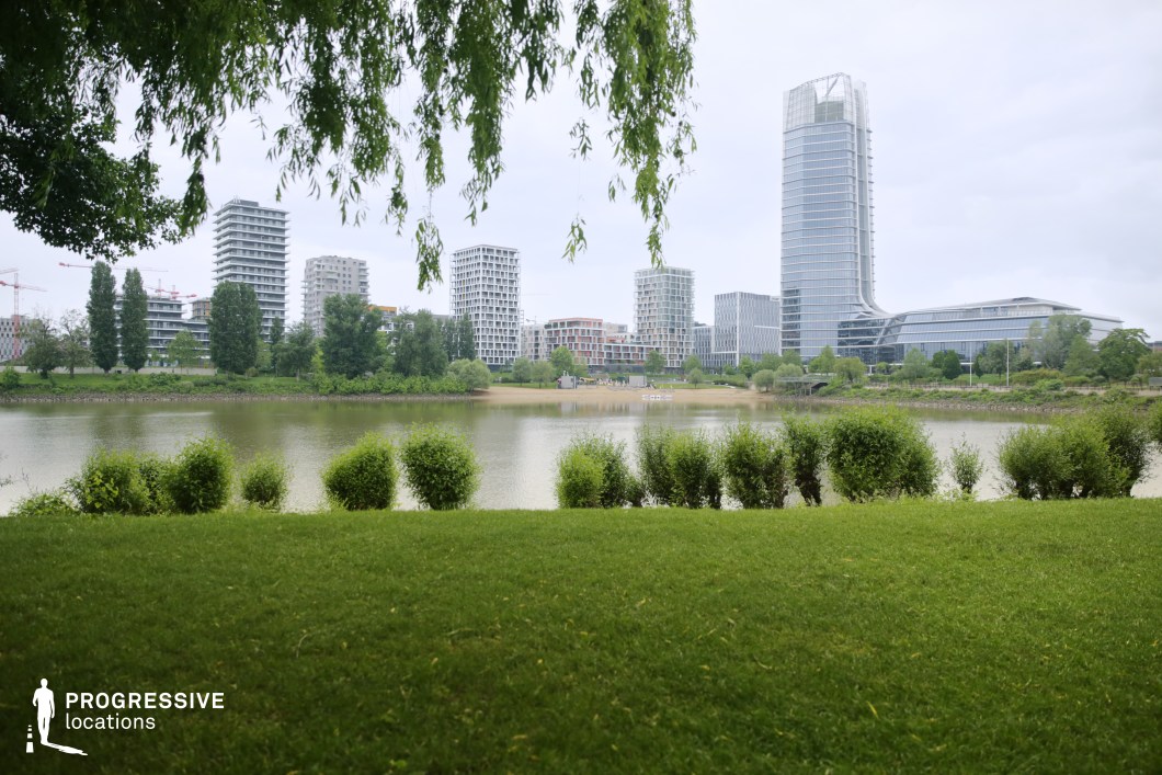 Urban lake and skyline, ideal film and photography location with modern buildings and green foreground
