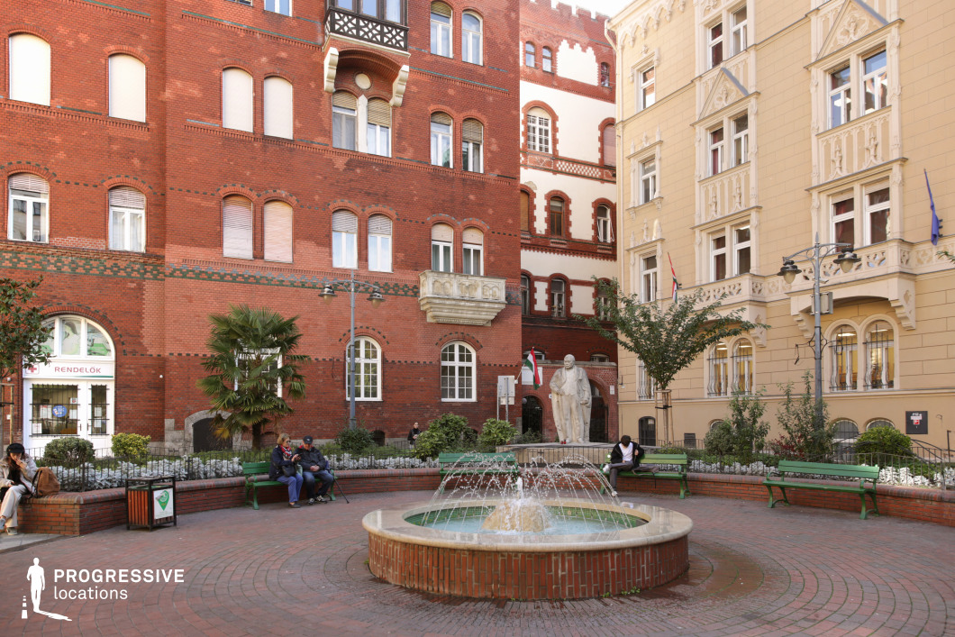 Circular fountain in enclosed courtyard with red brick buildings offers a film and photography location with central focal point