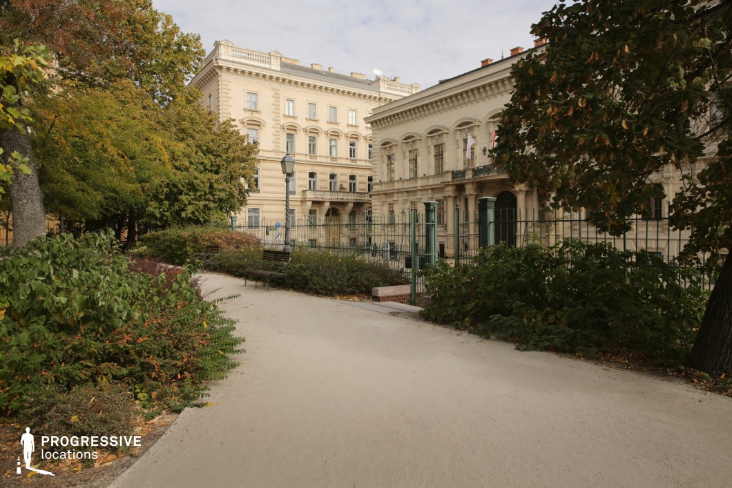 Garden path with dense greenery and historic facades works as a scenic film and photography location with depth and structure