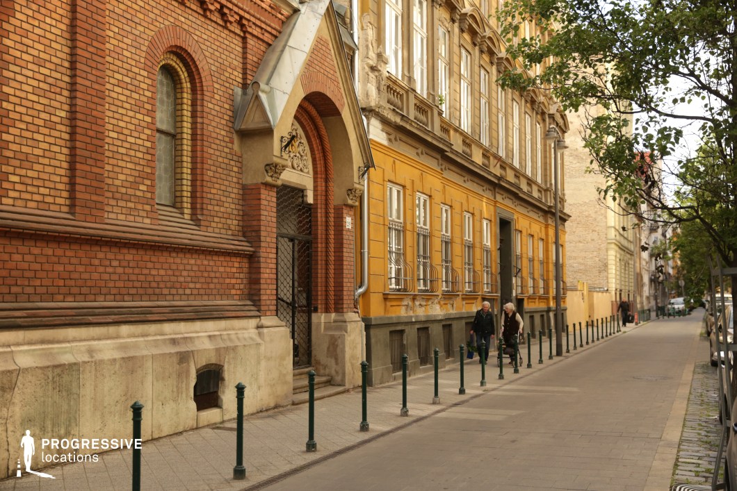 Quiet historic street with pedestrians and detailed facades offers a natural film and photography location with depth and perspective