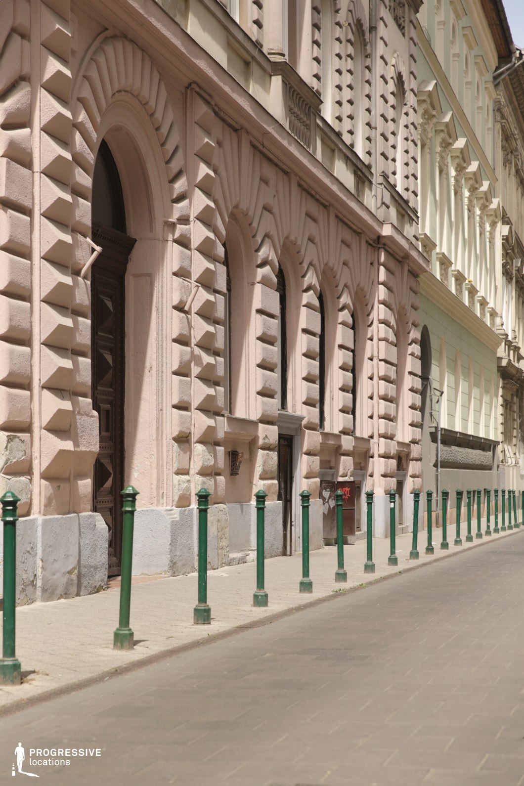Ornate street facade with repeating arches and bollards forms a film and photography location with strong perspective lines