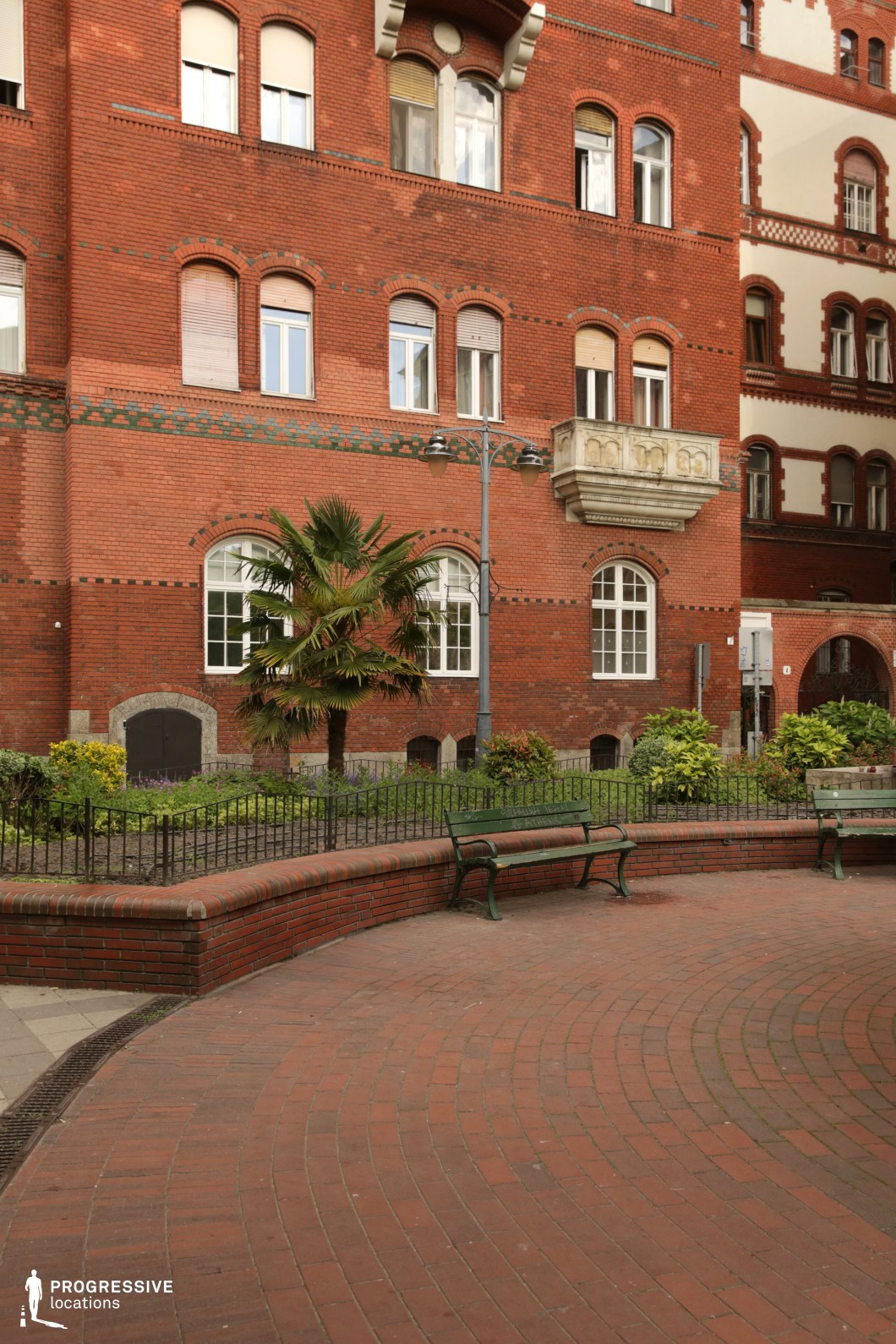 Red brick facade with arched windows and decorative masonry serves as a film and photography location focused on architectural detail