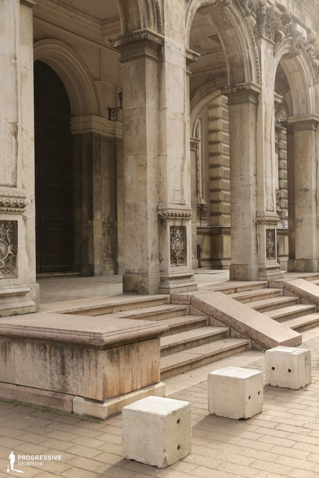 Stone columns and arched portico create a structured photography and film location with strong architectural framing