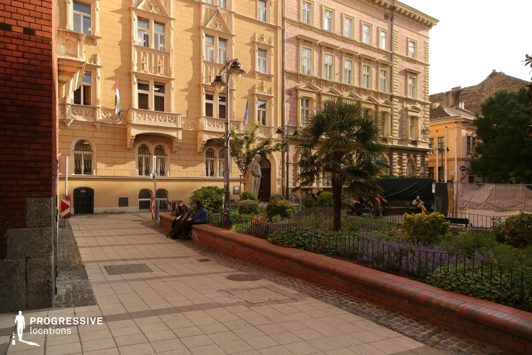 Urban park with benches and historic facades works as a versatile photography and film location combining greenery and architecture
