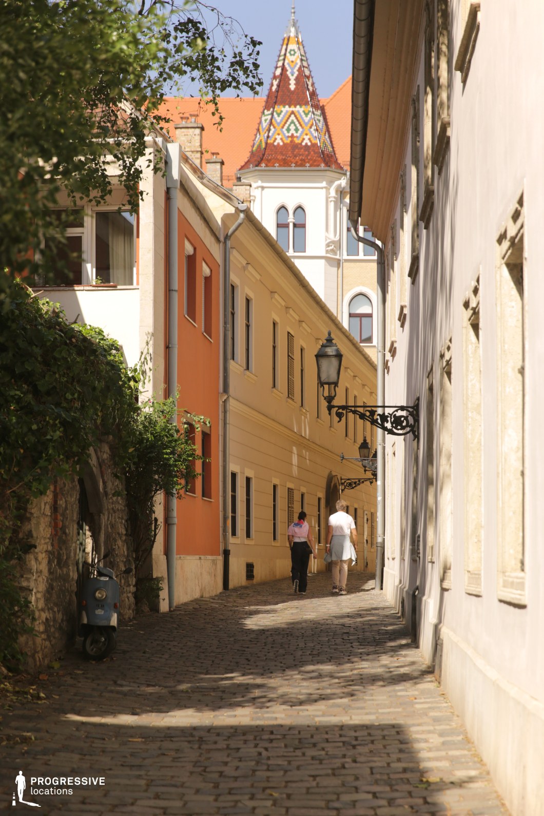 Narrow street toward tiled roof tower, ideal location for photography and filming