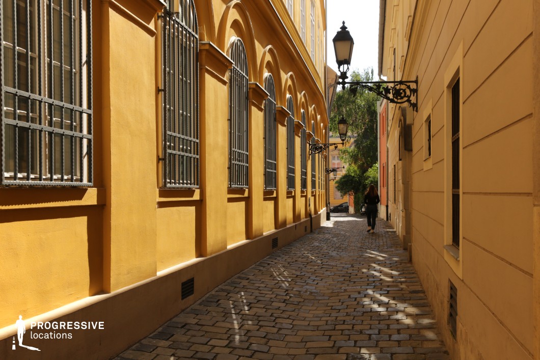 Yellow facade alley with arched windows, a film and photography location with strong geometry