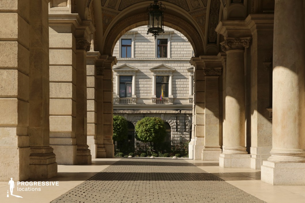 Film and photography location featuring vaulted stone arcades and a symmetrical passage within a historic building.