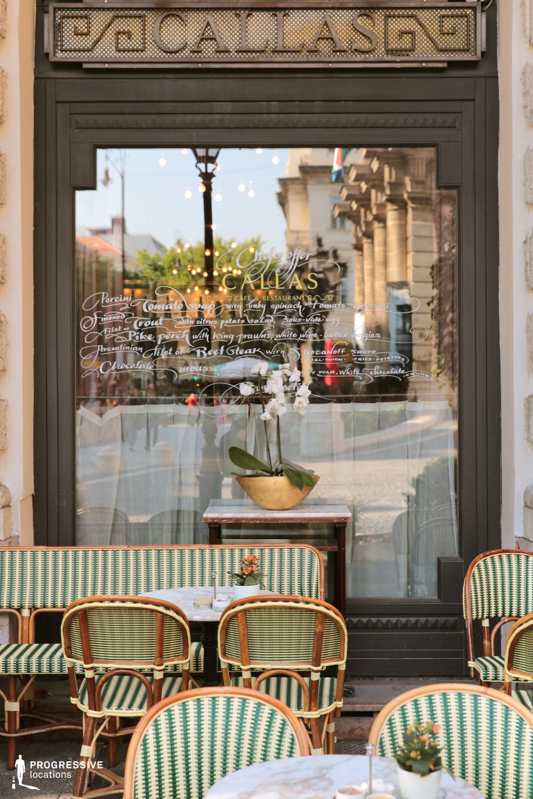 Classic cafe storefront with vintage seating featured as a photography and film location in a refined urban setting.