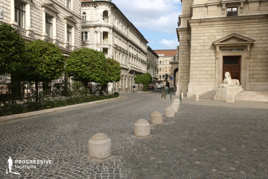 Curved cobblestone square with historic architecture creates a film and photography location in a formal urban setting.