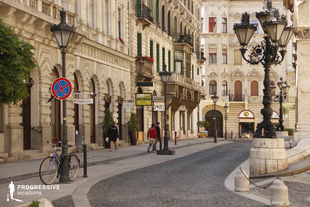 Elegant cobblestone street with ornate facades serves as a film and photography location in a historic urban district.