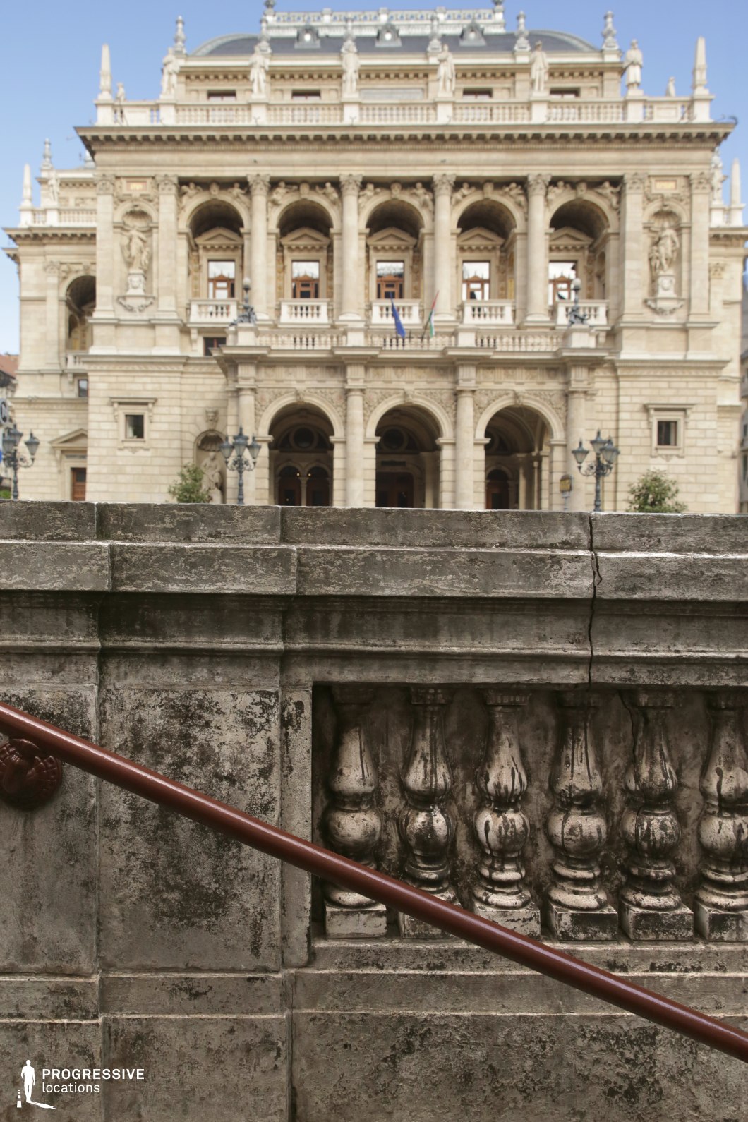 Grand opera facade behind a stone balustrade forms a photography and film location with monumental architecture.