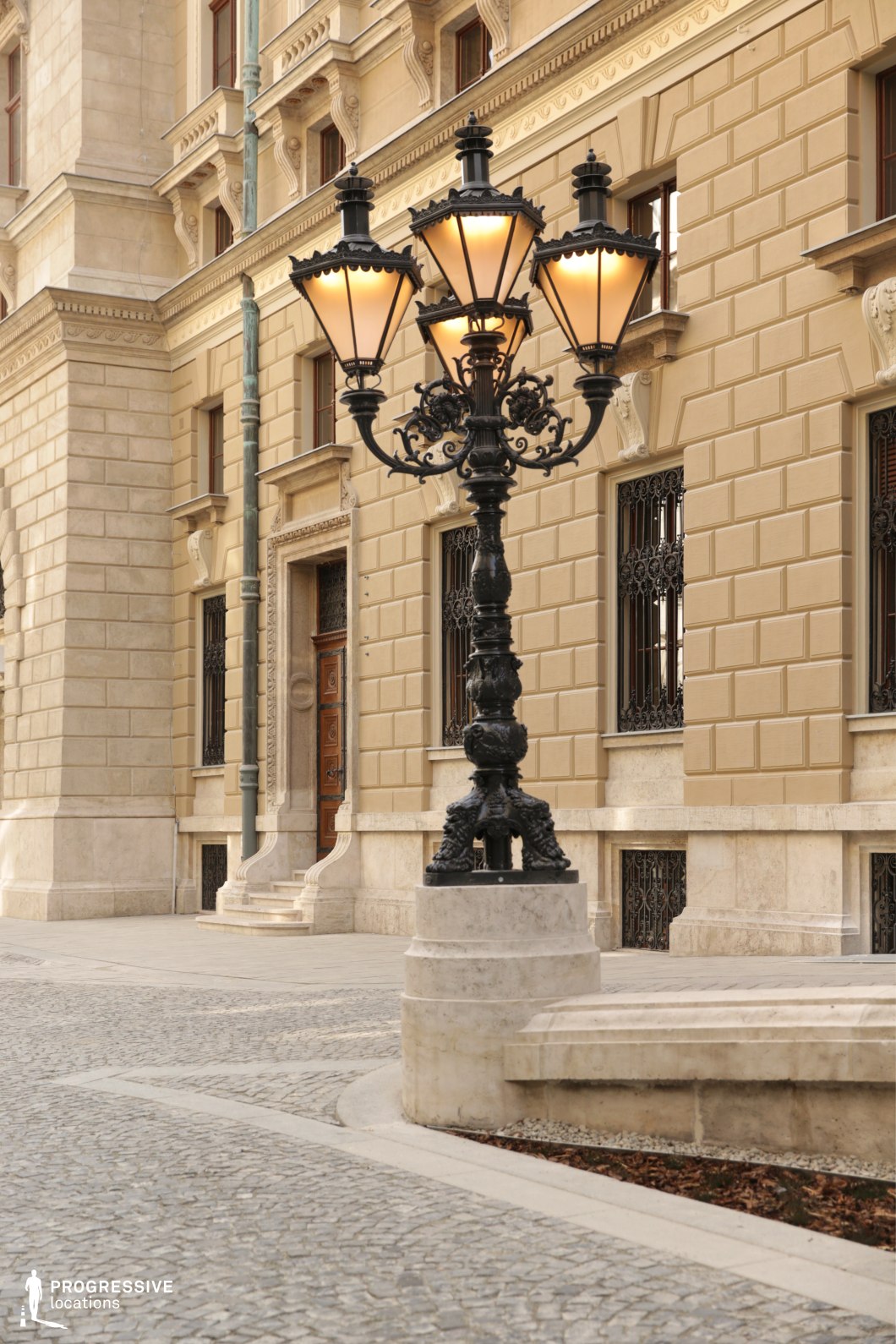 Ornate street lamp beside neoclassical stone architecture creates an ideal location for photography and filming.