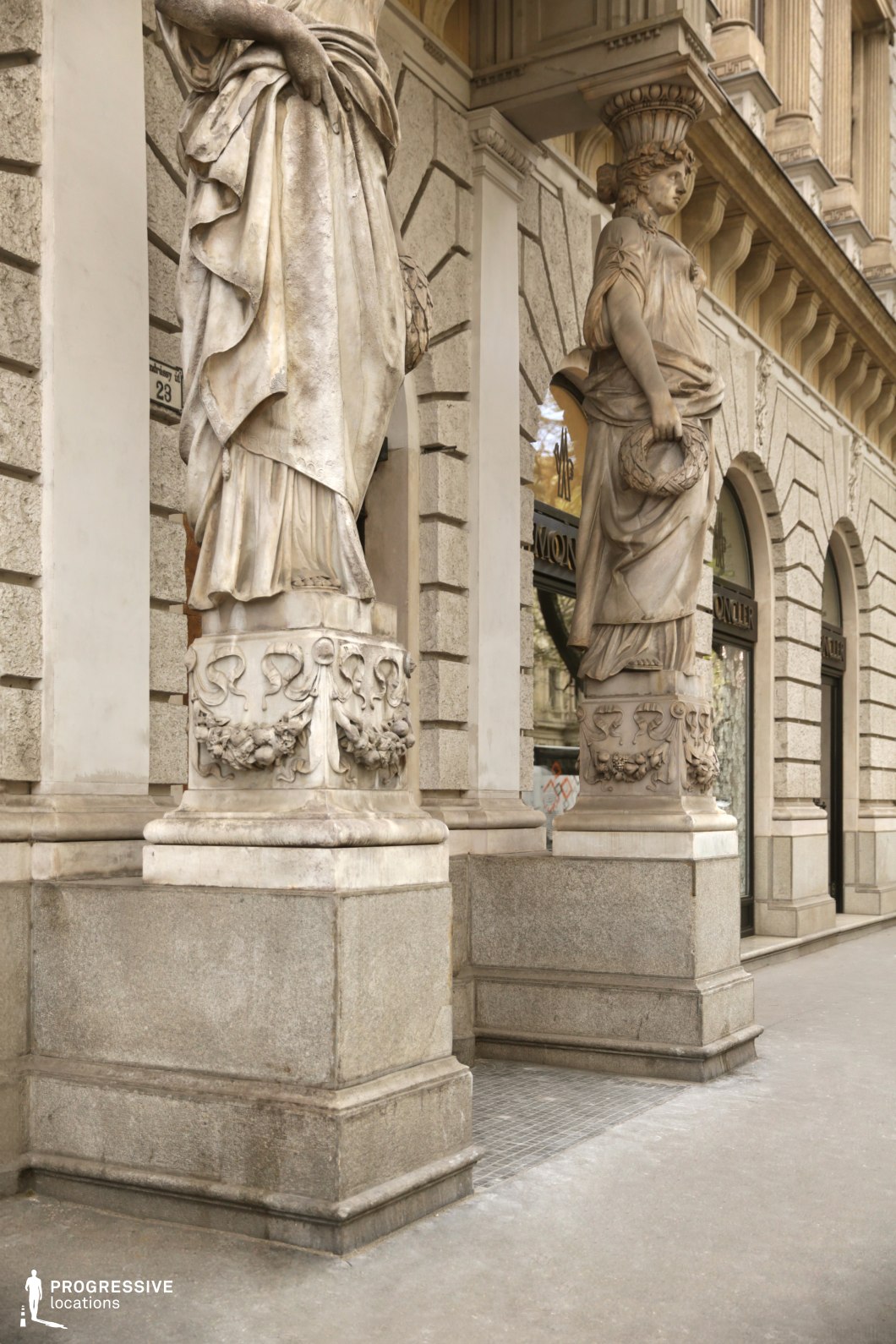 Classical statues along a historic stone facade create a photography and film location with sculptural architectural detail.