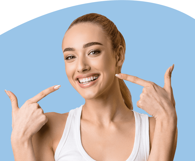 Woman pointing to teeth and smiling.