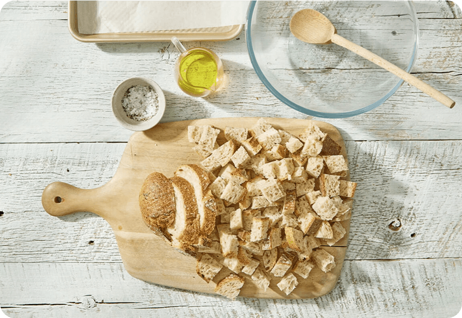 Chopping board with chopped up bread, next to oil and salt
