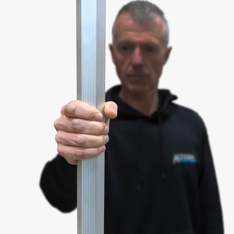 A person holds a lightweight aluminium pole, part of a gazebo structure, in a casual setting. The pole is silver.
