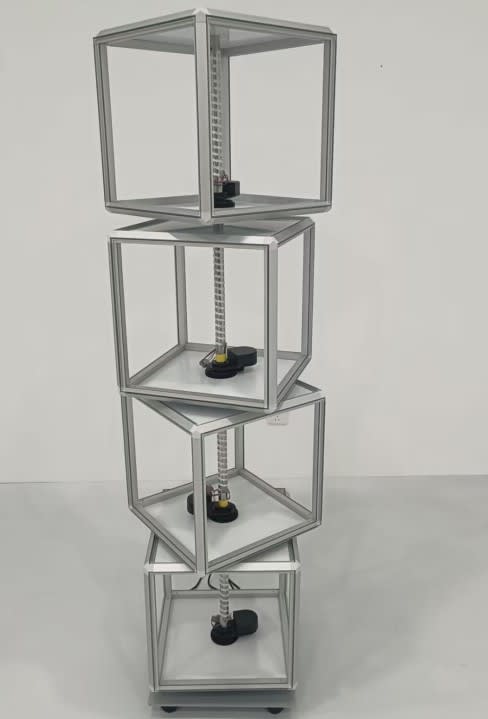 A rotating light box with transparent compartments, featuring a silver frame and black bases, designed for exhibitions and events.
