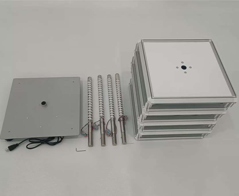 A rotating light box kit featuring a base, multiple panels, and three adjustable poles in silver and white.