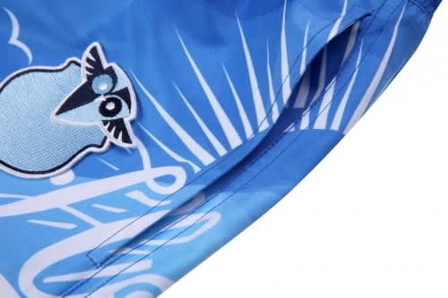 A blue beach shirt and shorts featuring a logo and vibrant graphics of clouds and sunbeams.