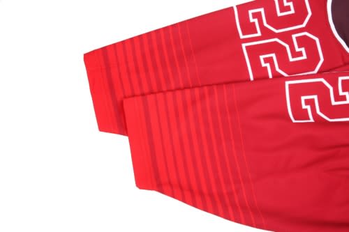 Red hockey team jersey with white lettering and stripes, featuring a logo on the upper area.