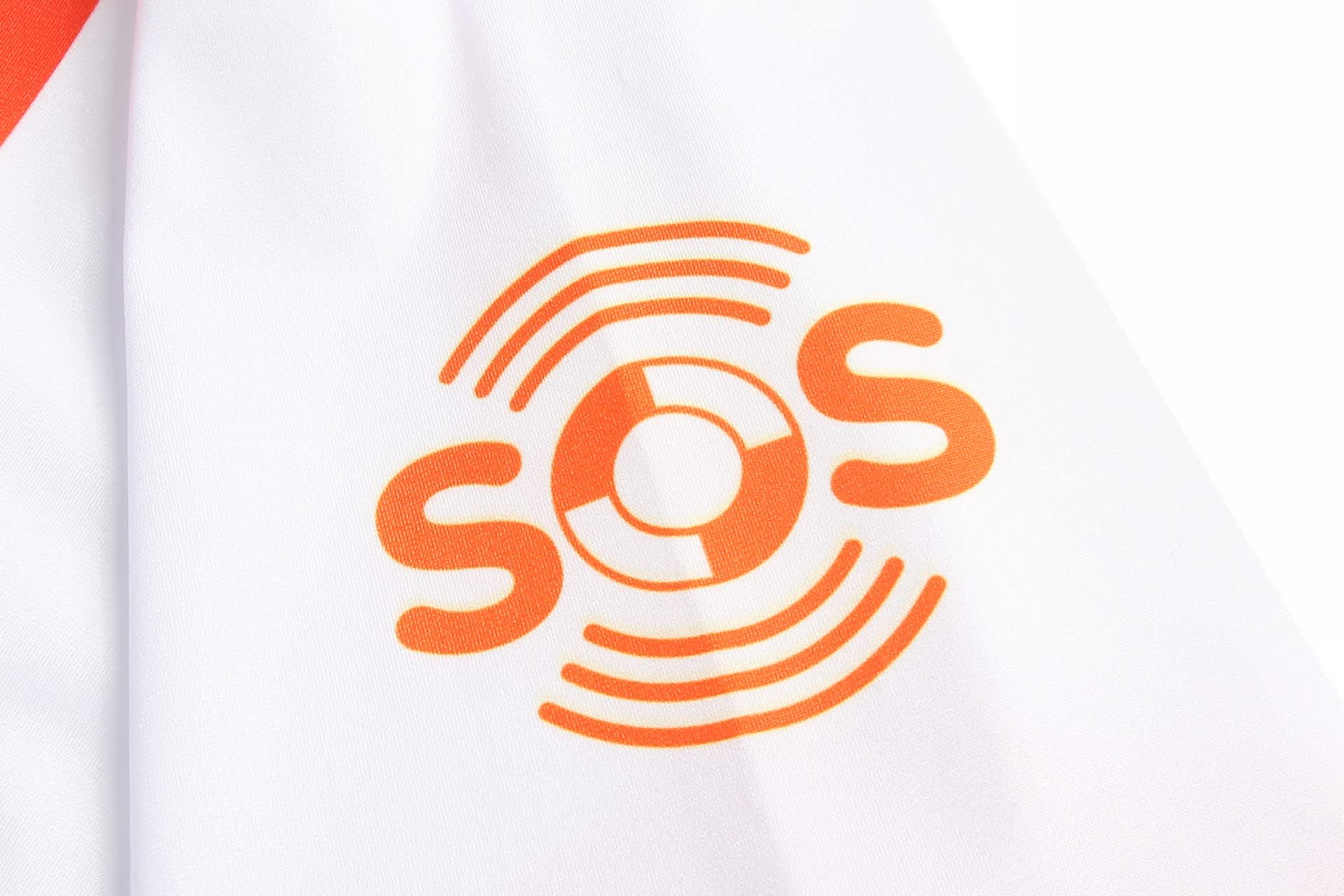 A white sports uniform featuring an orange logo with concentric circles and the letters "SOS".