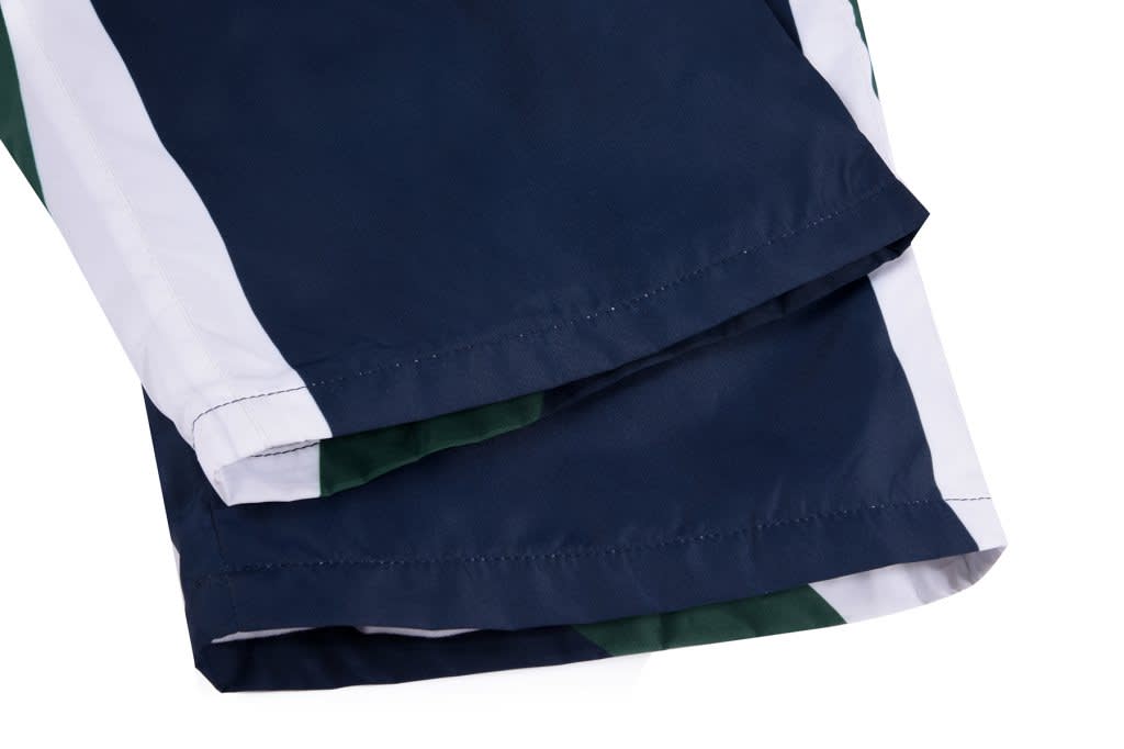 A sports uniform featuring dark navy blue and white colours, with green detailing and a logo.