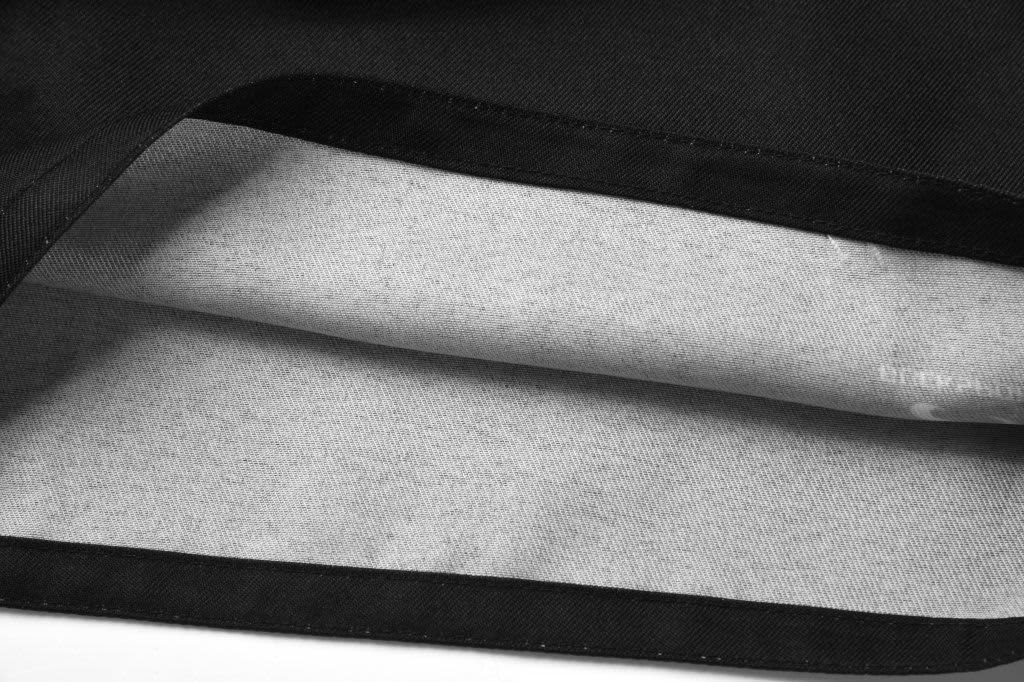 A pair of black rugby shorts, featuring a light grey lining, with an interior view showcasing the fabric details.