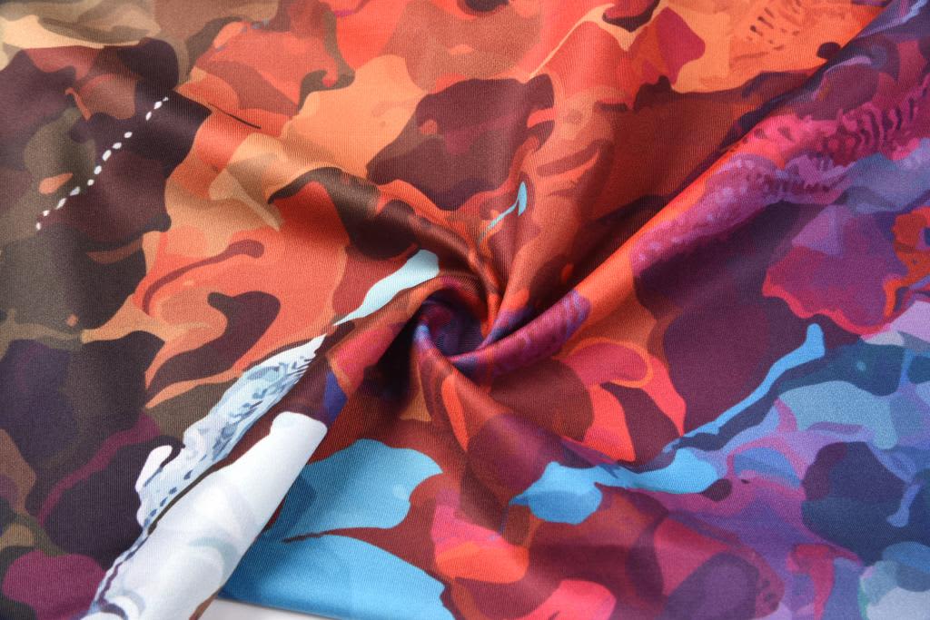 A patterned fabric featuring a blend of red, orange, blue, and purple hues, suitable for women's leggings.