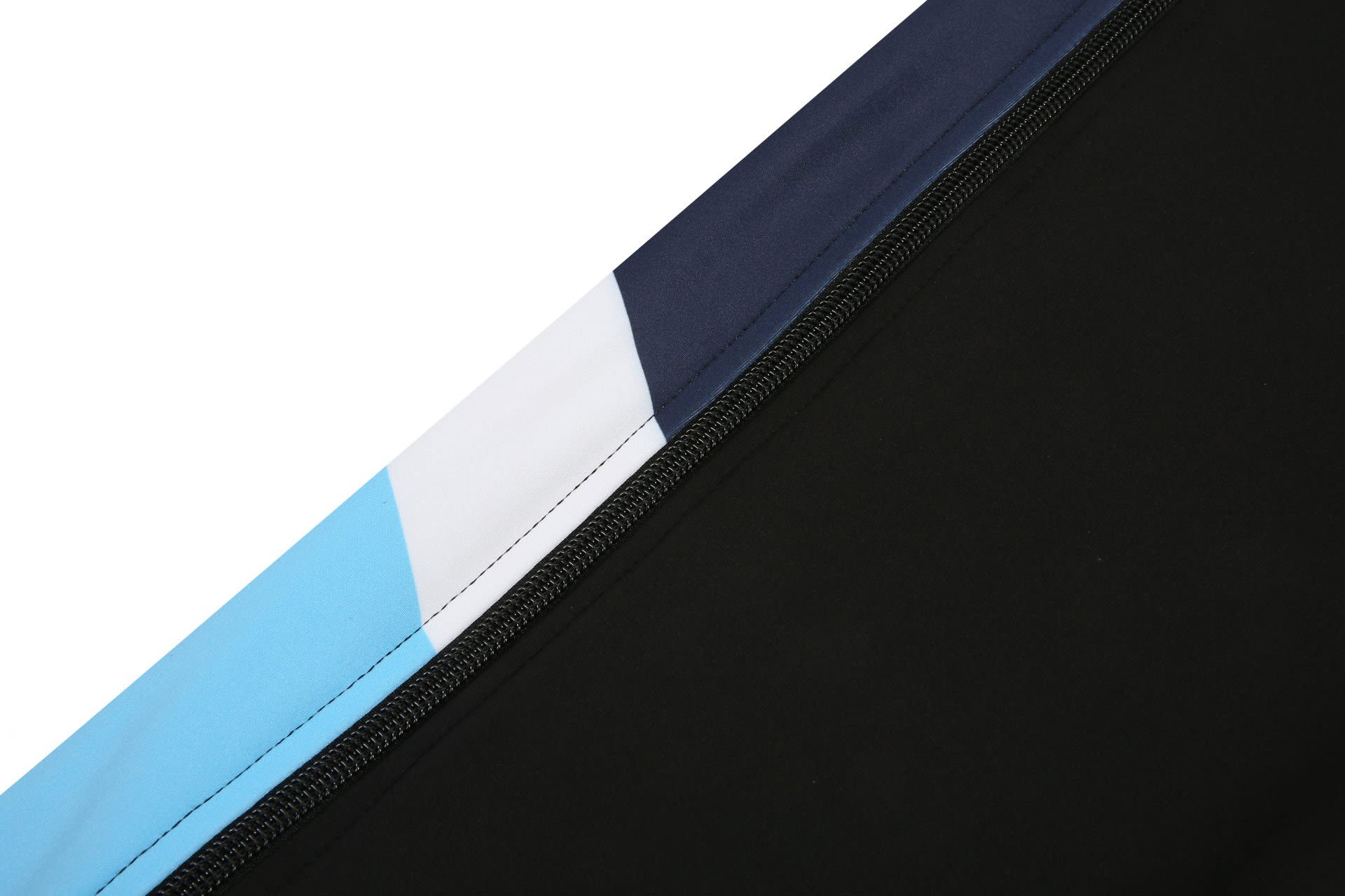A close-up of a track suit warm-up featuring black, light blue, and navy panels with a zipper.