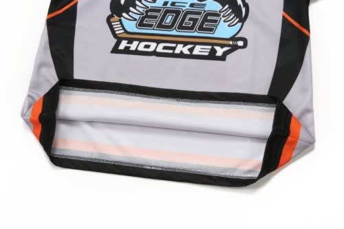 A grey ice hockey jersey featuring orange accents and a logo at the front, with a stitched hem and black details.