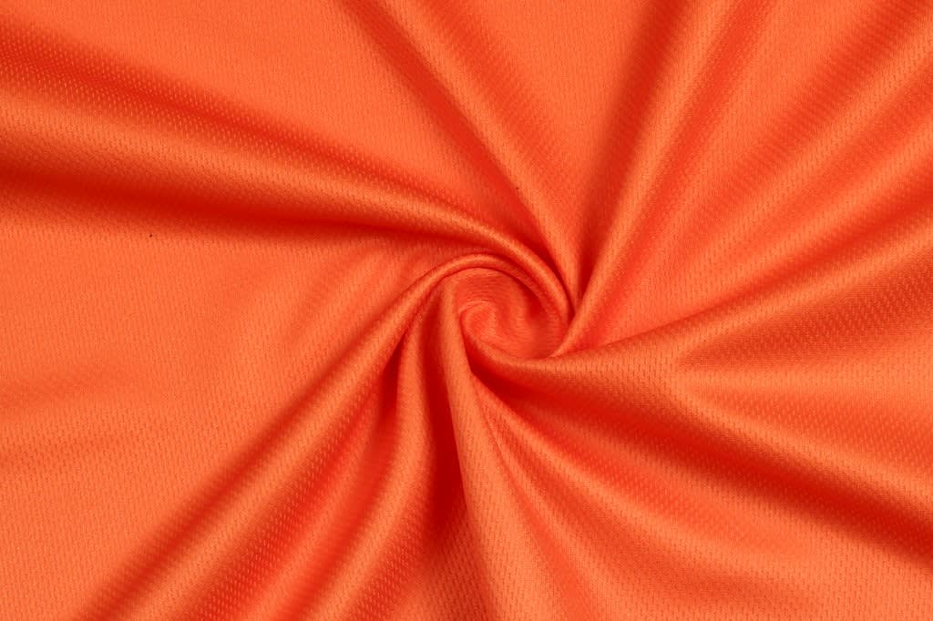An orange fabric, featuring a smooth texture, twisted in a spiral pattern.
